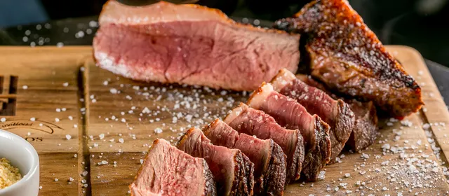 Picanha fatiada sobre tábua de madeira